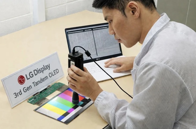 مهندس ال‌جی در حال بررسی پنل نسل سوم Tandem OLED با دستگاه اسپکتروفوتومتر